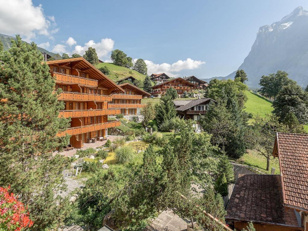un complejo en las montañas con árboles y edificios en Apartment Chalet Smaragd-3 by Interhome, en Grindelwald