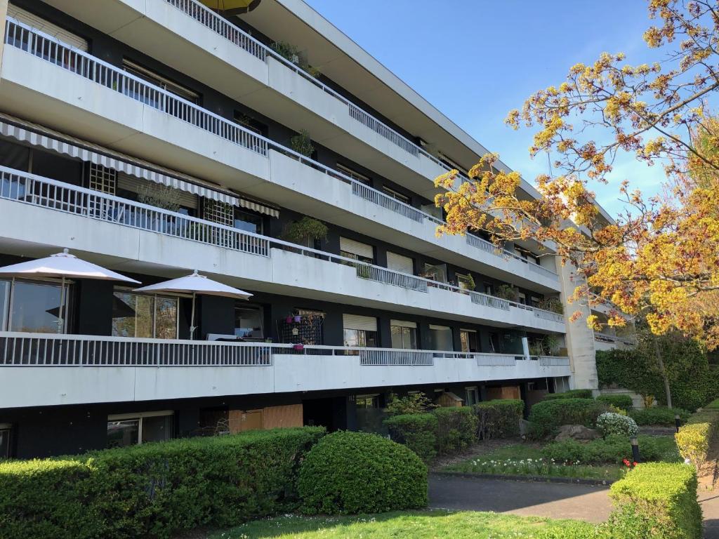 un immeuble d'appartements avec une cour dotée de parasols dans l'établissement Georges Sand, à Châtenay-Malabry