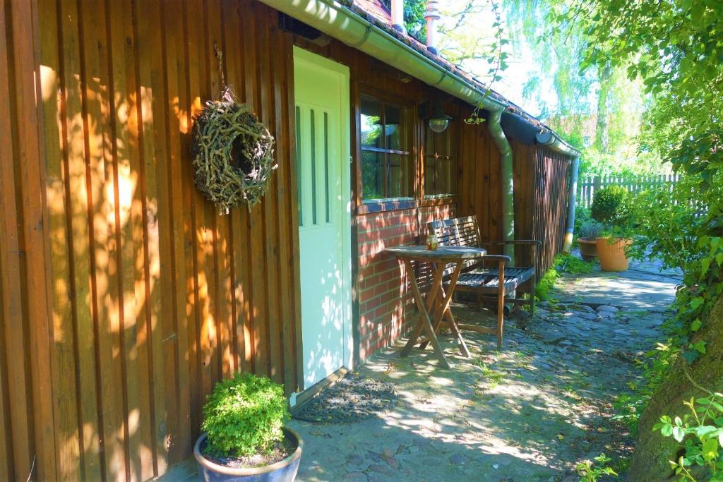 a porch of a house with a table and a door at FeWo Jacob in Garlstorf