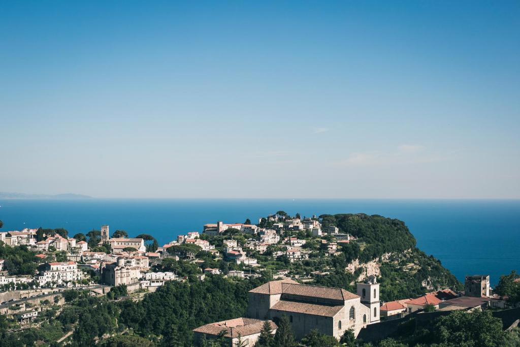 een stad op een heuvel met de oceaan op de achtergrond bij Amalfi Coast Holiday House in Scala