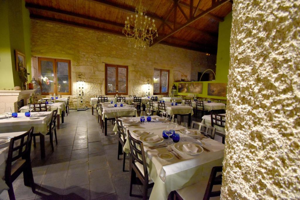un comedor con mesas y sillas blancas en HOTEL RURAL A VELHA FABRICA, en Valverde del Fresno