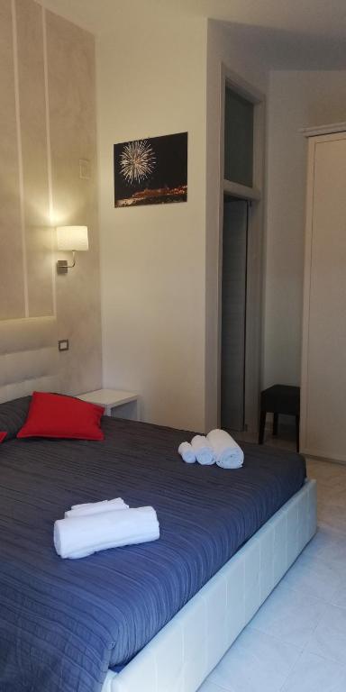 a bedroom with a blue bed with towels on it at Sea Garden Rooms in Termoli