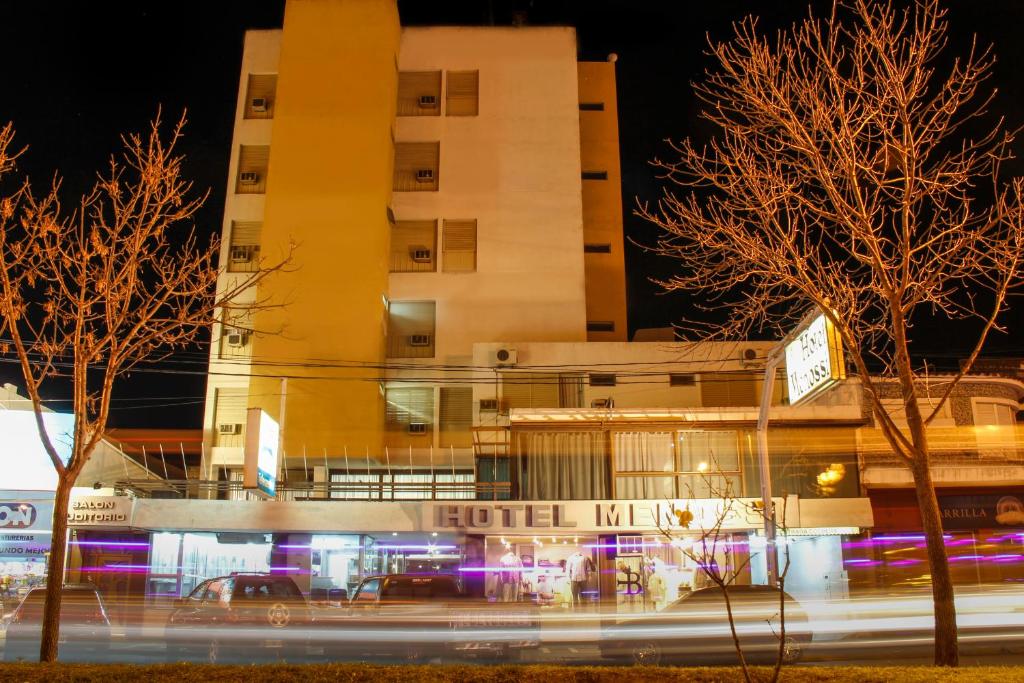 un edificio con un hotel delante de él por la noche en Hotel Menossi en Río Cuarto