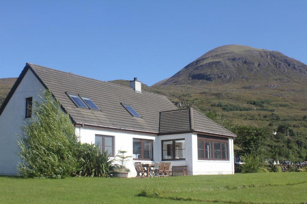 a white house with a mountain in the background at Ben View in Torridon