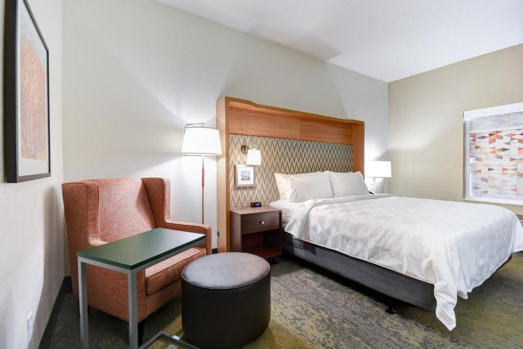 a hotel room with a bed and a chair at Holiday Inn Allentown-Bethlehem by IHG in Allentown