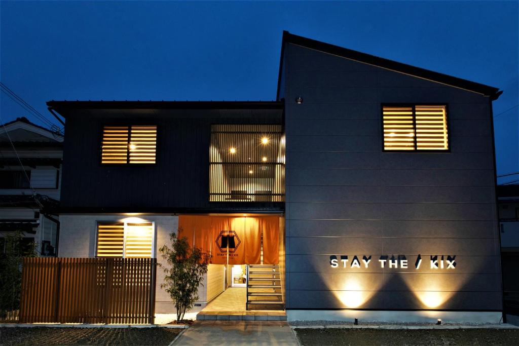 Czarny dom z napisem "Zostań tam" w obiekcie Apartment Hotel STAY THE Kansai Airport w mieście Izumisano