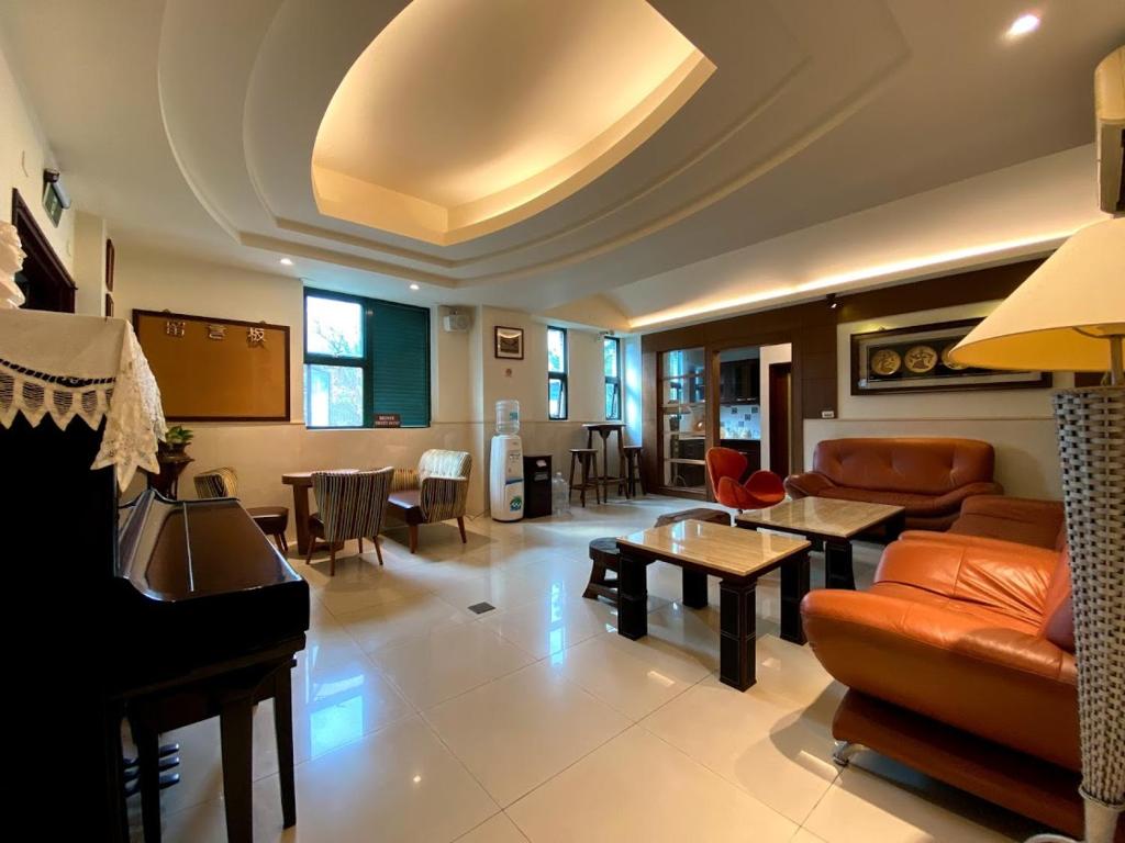 a living room with a couch and a piano at Ho Feng Private Hotel 電梯自助民宿 in Ji&#39;an