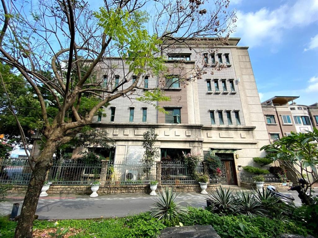 a large building with a tree in front of it at Ho Feng Private Hotel 電梯自助民宿 in Ji&#39;an