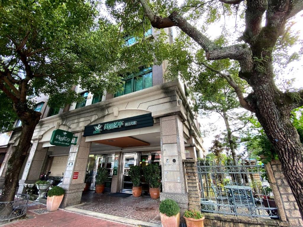 a building with potted plants in front of it at Ho Feng Private Hotel 電梯自助民宿 in Ji&#39;an