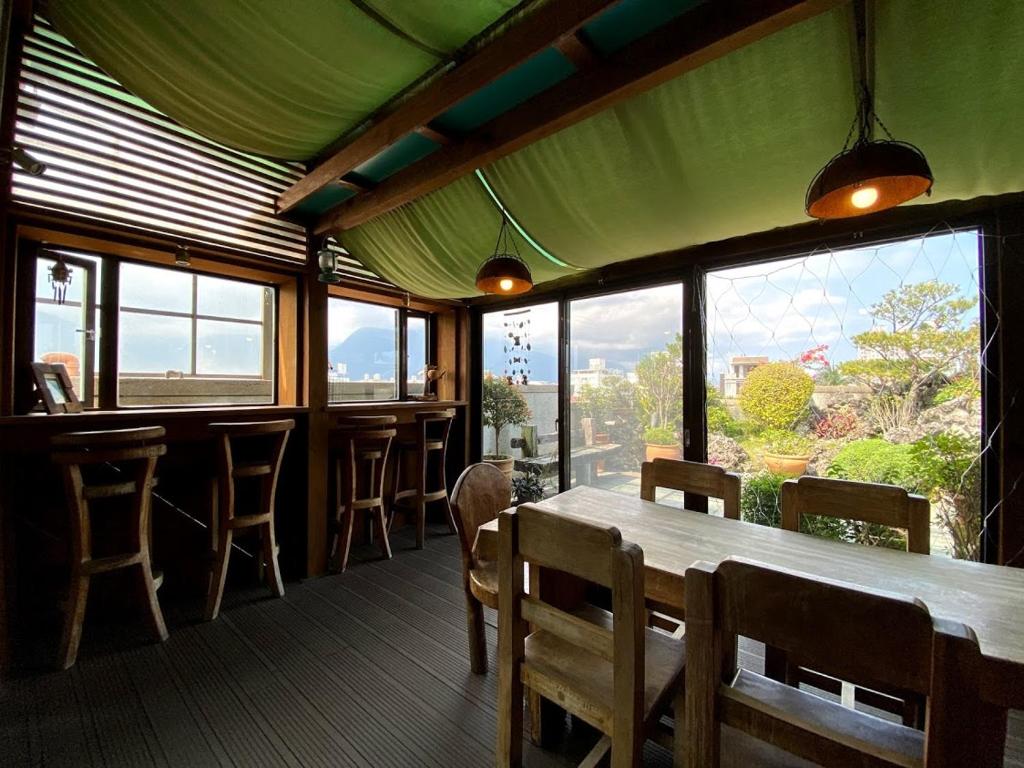 a restaurant with a table and chairs and windows at Ho Feng Private Hotel 電梯自助民宿 in Ji&#39;an