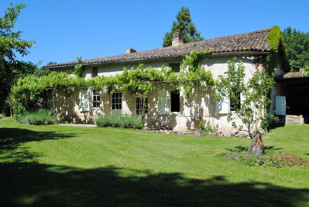 Maison des Vignes في Le Fleix: منزل حجري قديم مع اللبي ينمو عليه