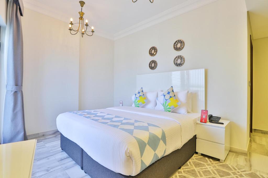 a bedroom with a large bed and a chandelier at OYO 490 Home Marbella 2 BR in Dubai