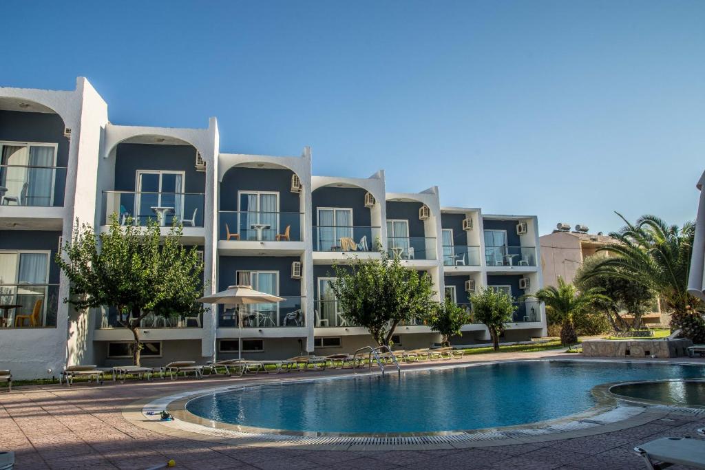 an apartment building with a swimming pool in front of it at Sevastos Studios in Faliraki