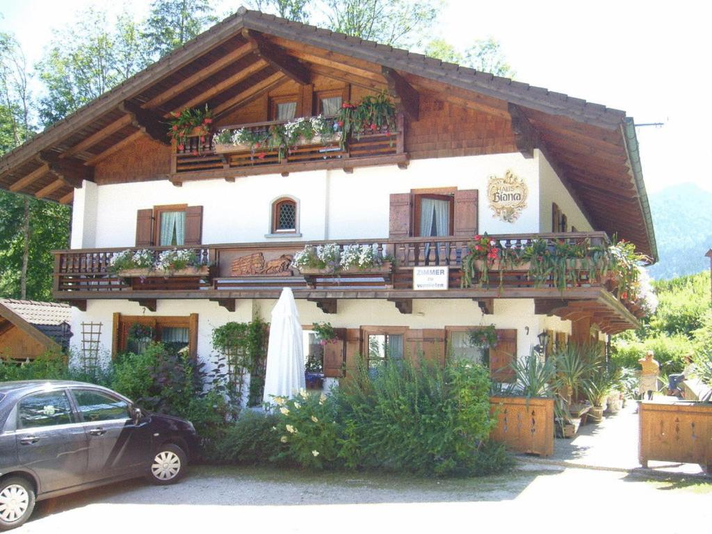 a house with a balcony and a car parked in front at Alpenchalet Bianca in Ramsau