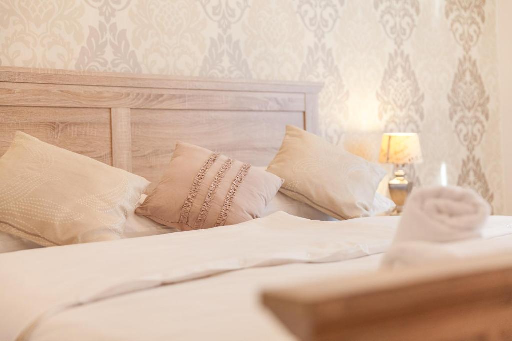 a bed with white sheets and pillows and a lamp at Vacation house Artorius in Ljubljana