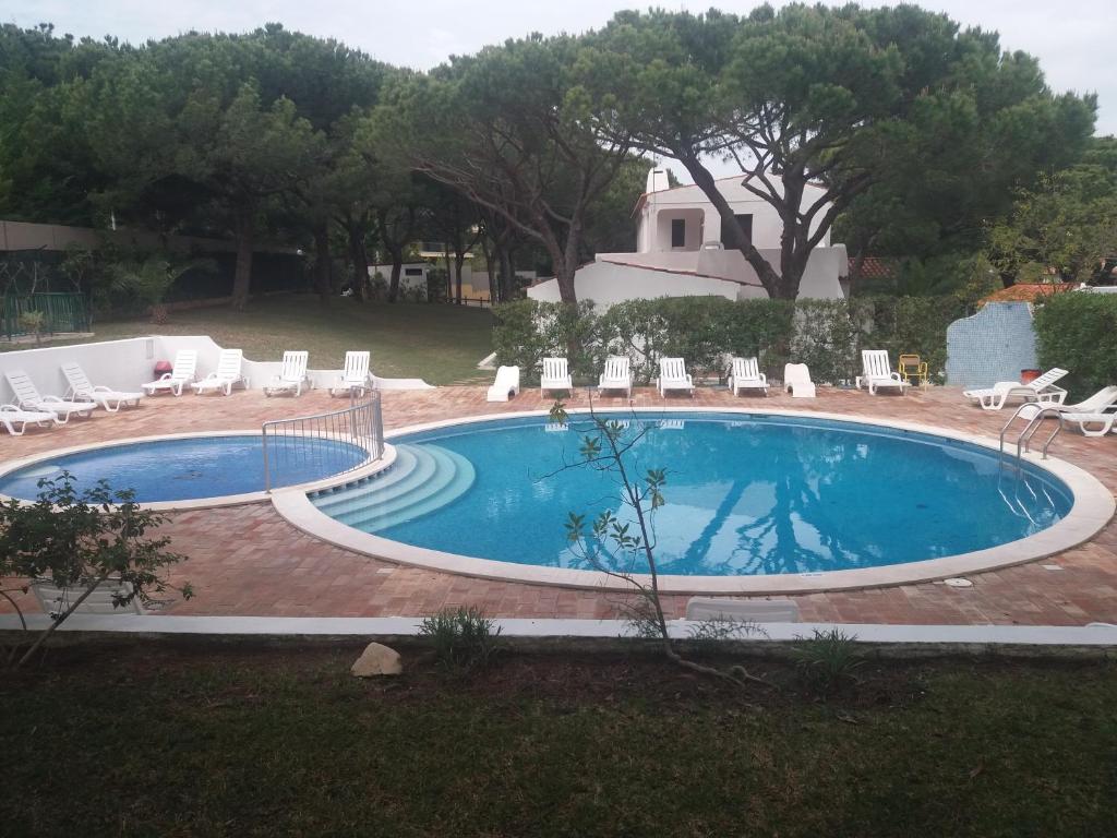 a large swimming pool with chairs at Aldeia Da Falesia in Albufeira