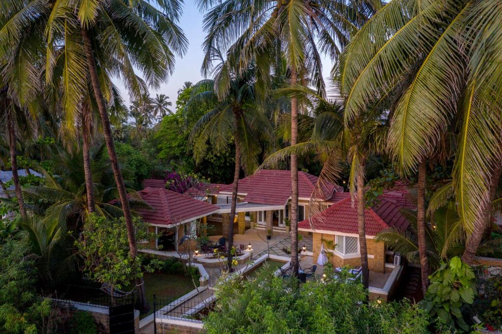 an aerial view of a house with palm trees at amã Stays & Trails, Beach House Madh Island in Mumbai