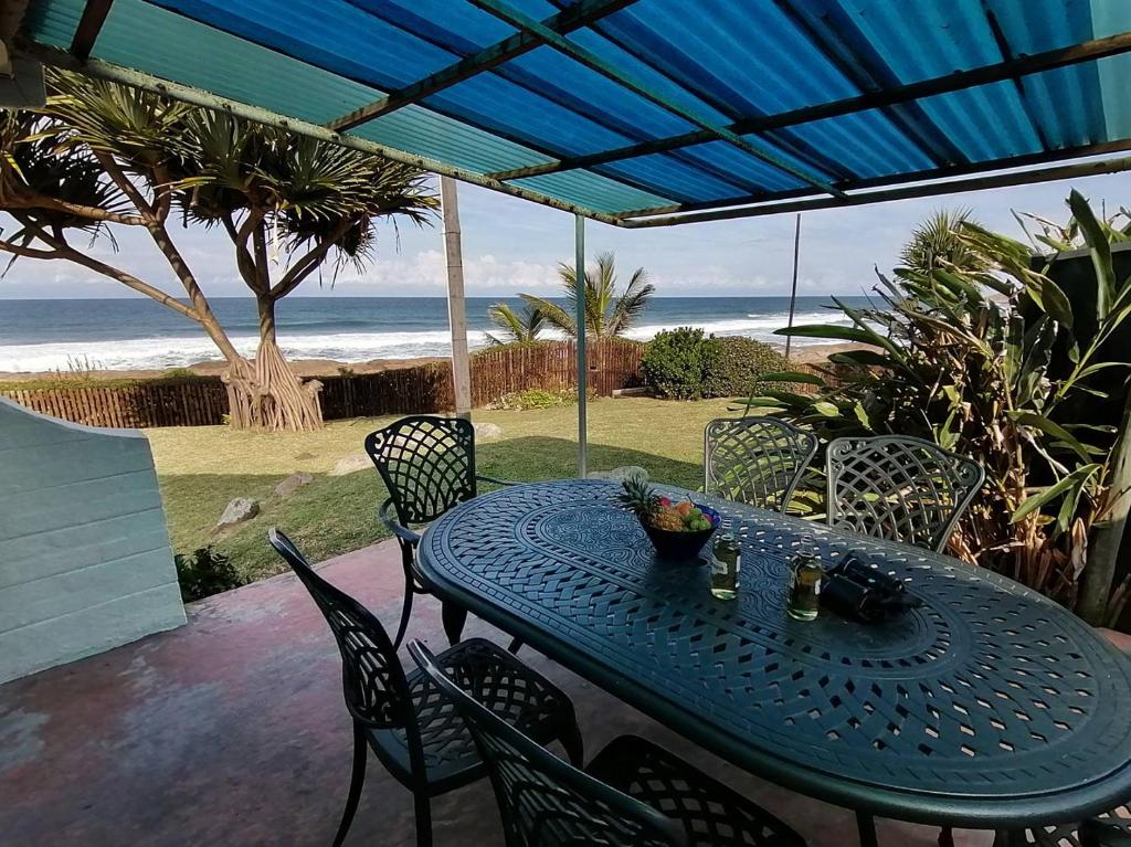 - une table bleue et des chaises sur une terrasse donnant sur la plage dans l'établissement Southern Comfort - On the Sea, à Margate