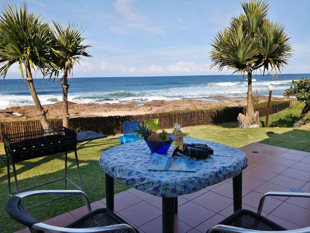 a table and chairs on a patio with a view of the ocean at Southern Comfort - Periwinkle in Margate