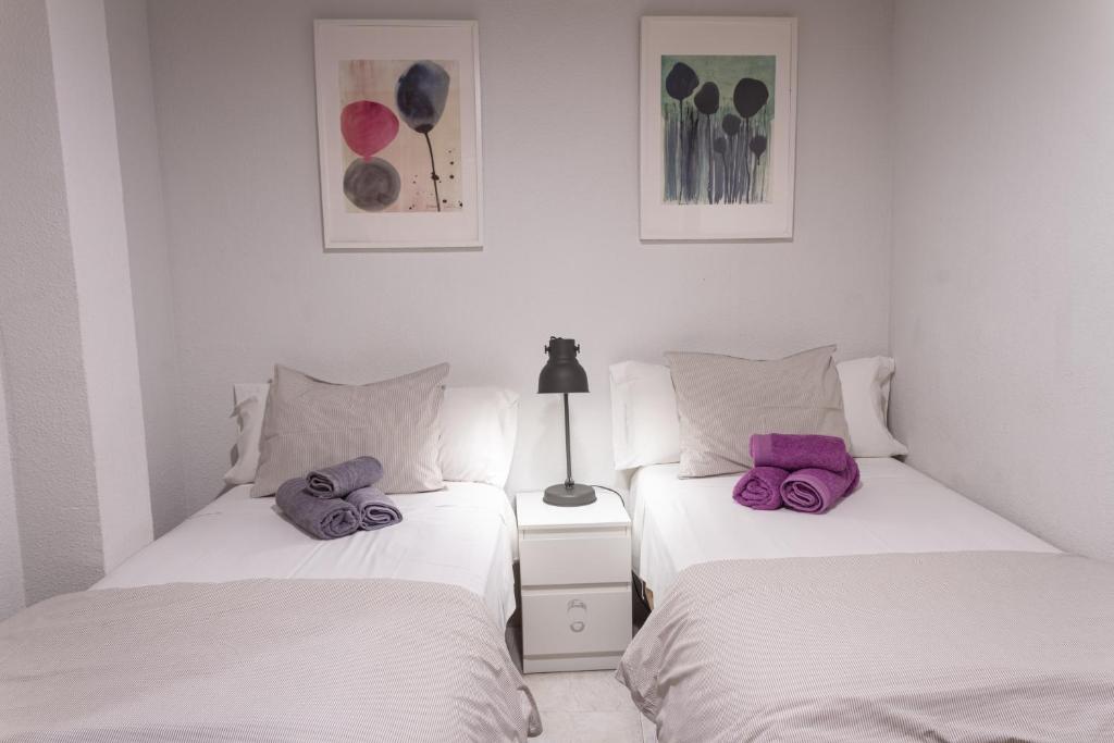 two beds sitting next to each other in a bedroom at Apartamentos La Machacona Plaza Mayor in Cáceres