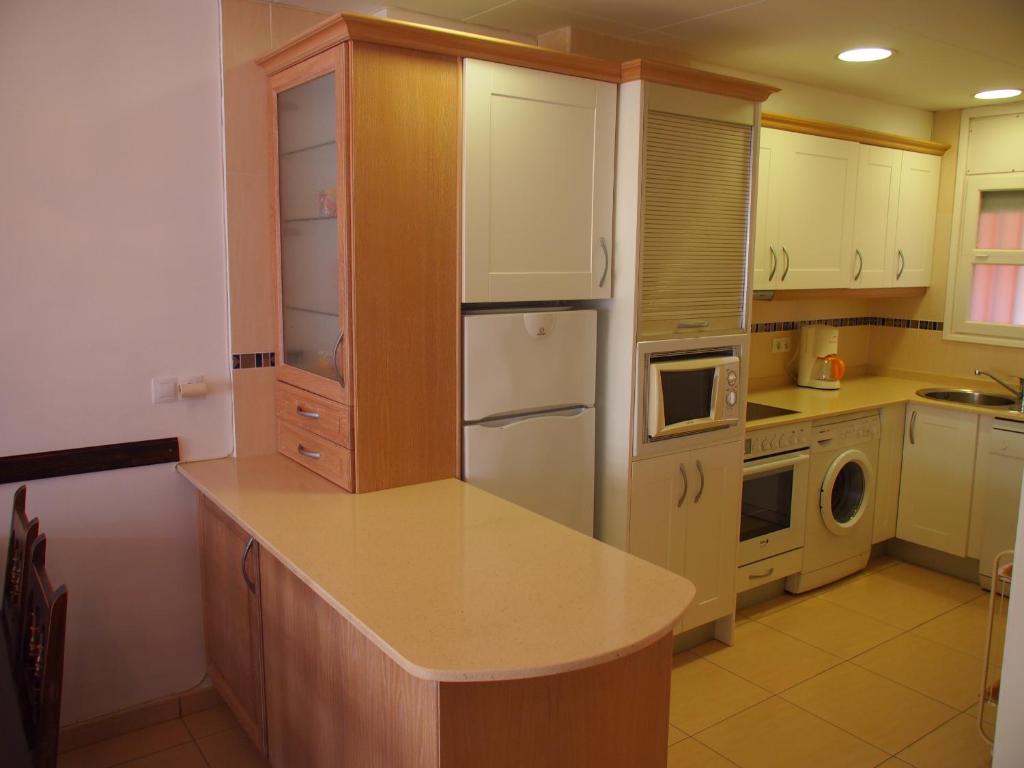 a kitchen with a white refrigerator and a microwave at ROSES 4 in Roses