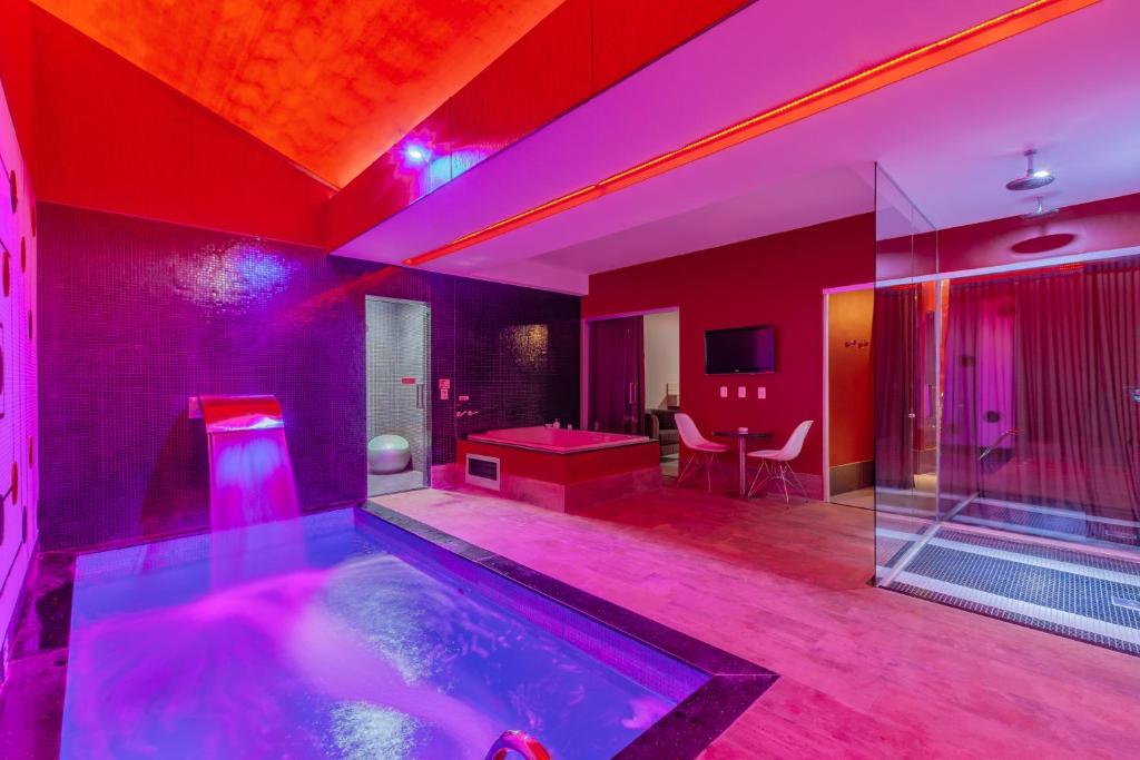 a room with a swimming pool with purple lighting at Assahi Motel (Adult Only) in Fortaleza