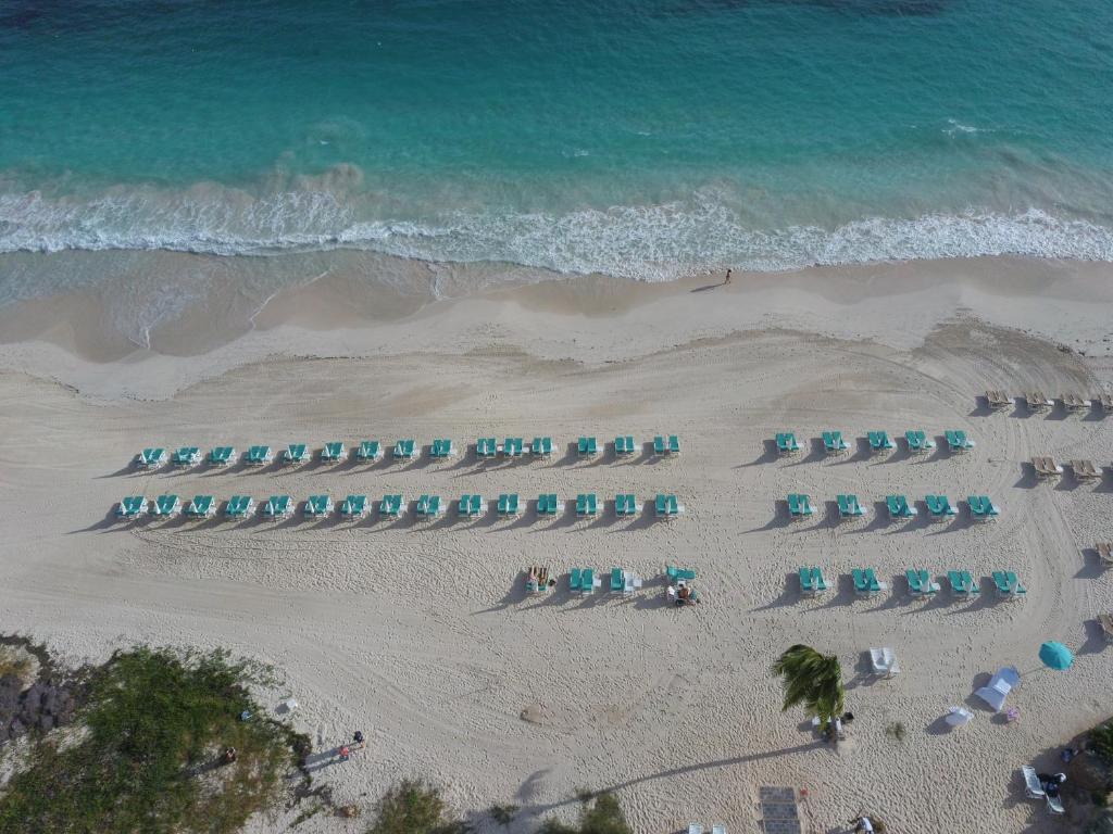 an overhead view of a beach with chairs and the ocean at La Playa Orient Bay in Orient Bay