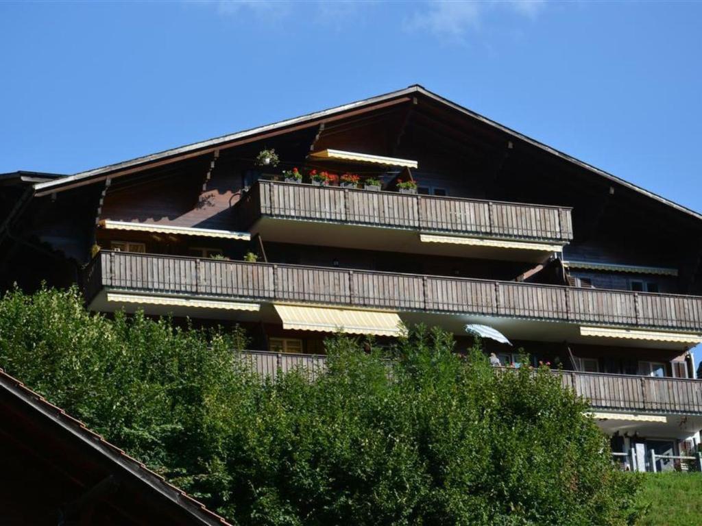 un edificio con gente sentada en sus balcones en Apartment Hübeli - Chapman by Interhome en Zweisimmen