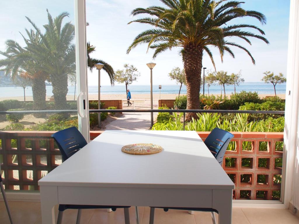 d'une table et de chaises sur un balcon avec vue sur la plage. dans l'établissement MIRAMAR 2B, à Roses