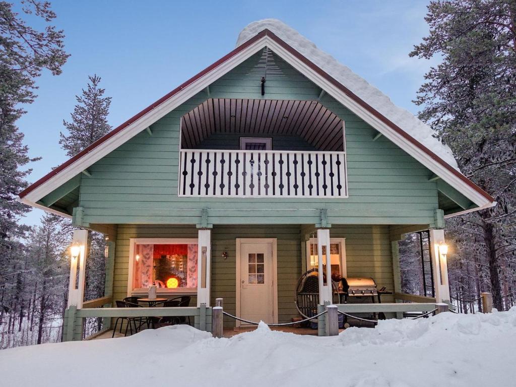 Holiday Home Jäkälätieva by Interhome في Raattama: منزل أخضر مع شرفة في الثلج