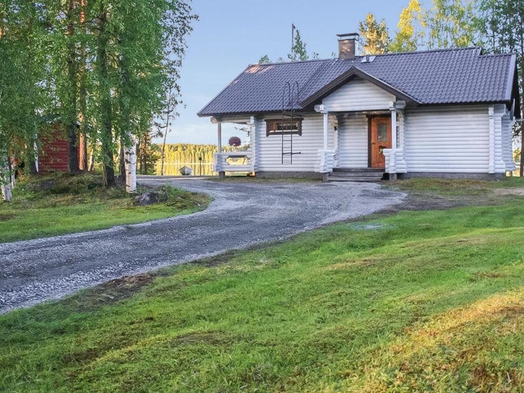 uma casa com uma estrada de cascalho em frente em Holiday Home Suvituuli by Interhome em Pertunmaa