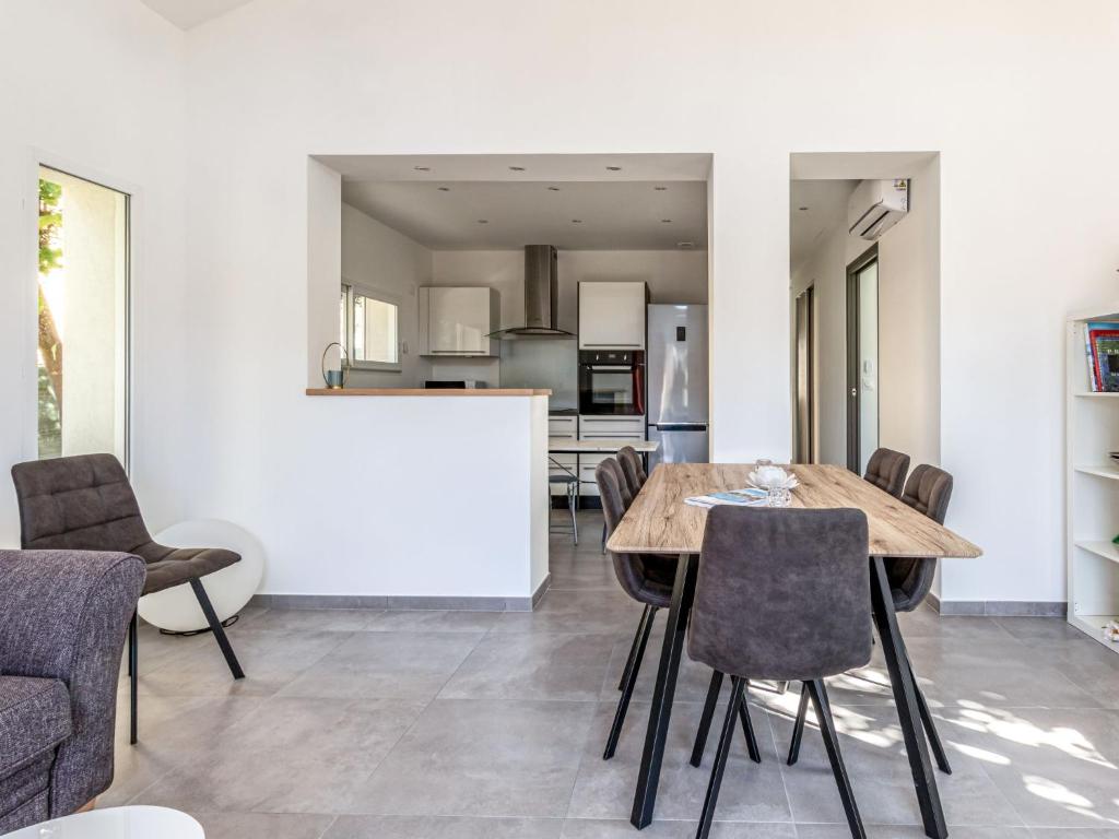 cocina y comedor con mesa de madera y sillas en Villa Mont des oiseaux by Interhome, en Toulon