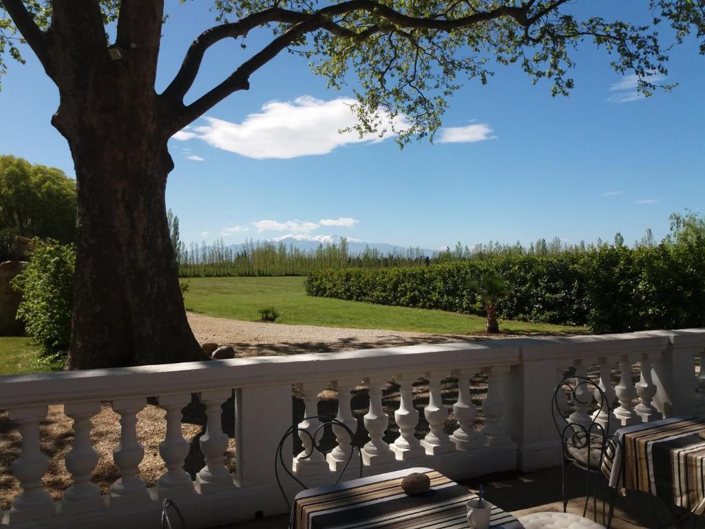 une clôture blanche avec des chaises et un arbre dans l'établissement Domaine Castell de Blés, à Saint-Génis