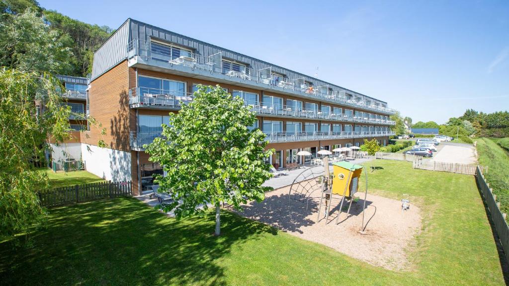 an apartment building with a tree in front of it at Vacancéole - Le Domaine du Mont - Mont St Michel in Roz-sur-Couesnon