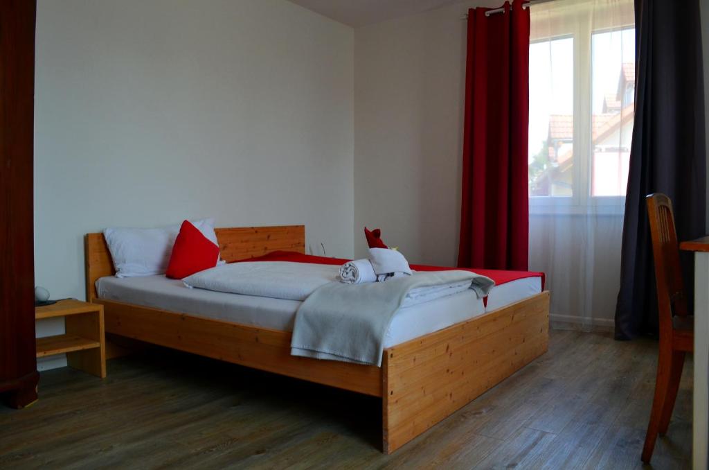 a bedroom with a wooden bed with red pillows at Hotel "Cafe Verkehrt" - Wellcome Motorbiker, Berufsleute und Reisende im Schwarzwald in Oberhof