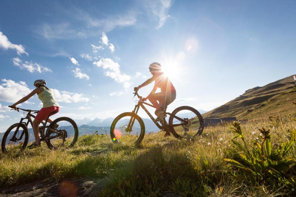 a man and a woman riding bikes in a field at Hotel Montpelier in Verbier