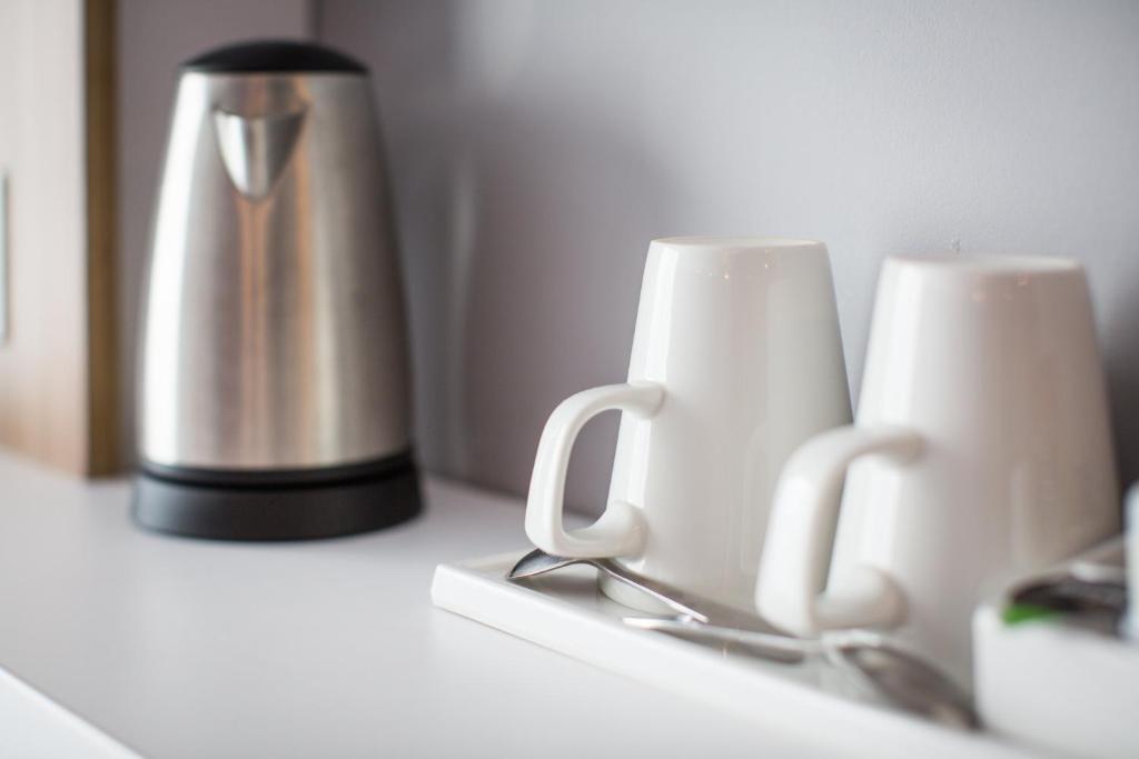two coffee cups sitting on a counter next to a thermos at Holiday Inn Express Amsterdam - North Riverside by IHG in Amsterdam