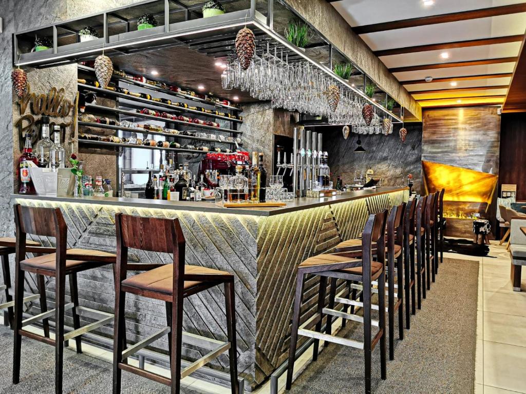 eine Bar in einem Restaurant mit braunen Stühlen in der Unterkunft Gasthof Schlossberghof in Lienz