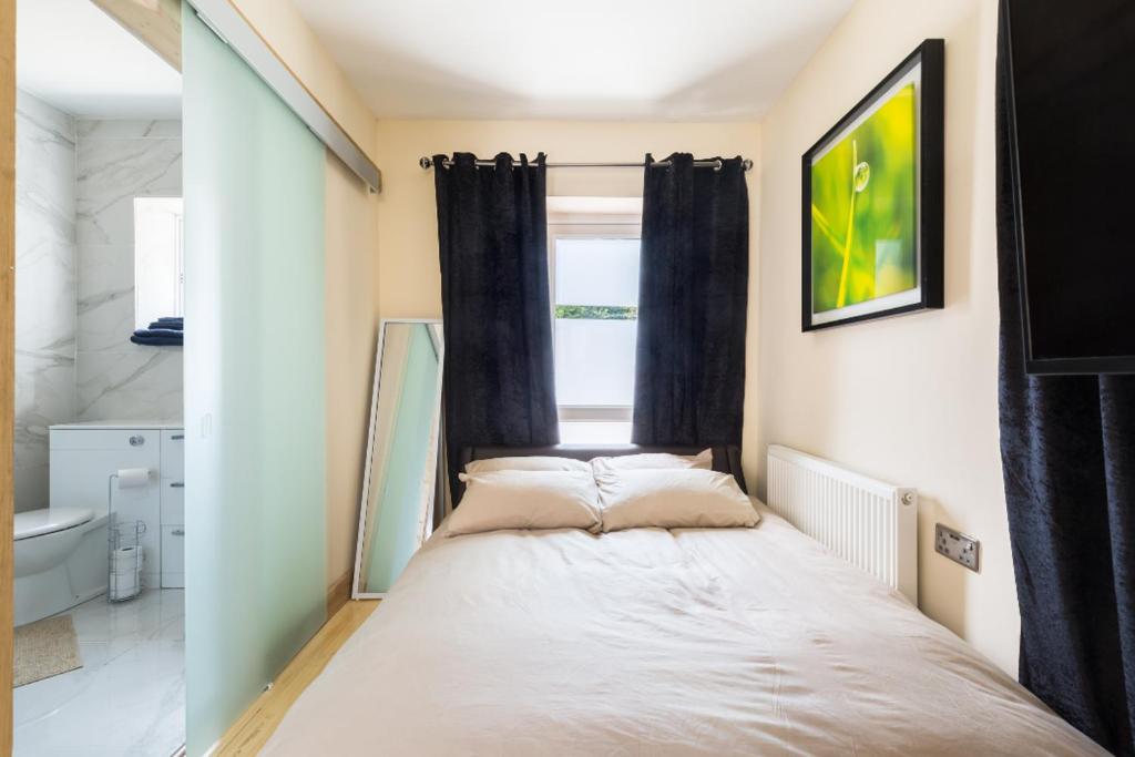 Cama pequeña en habitación con ventana en Umbrella Properties Private Apartment Birmingham en Birmingham