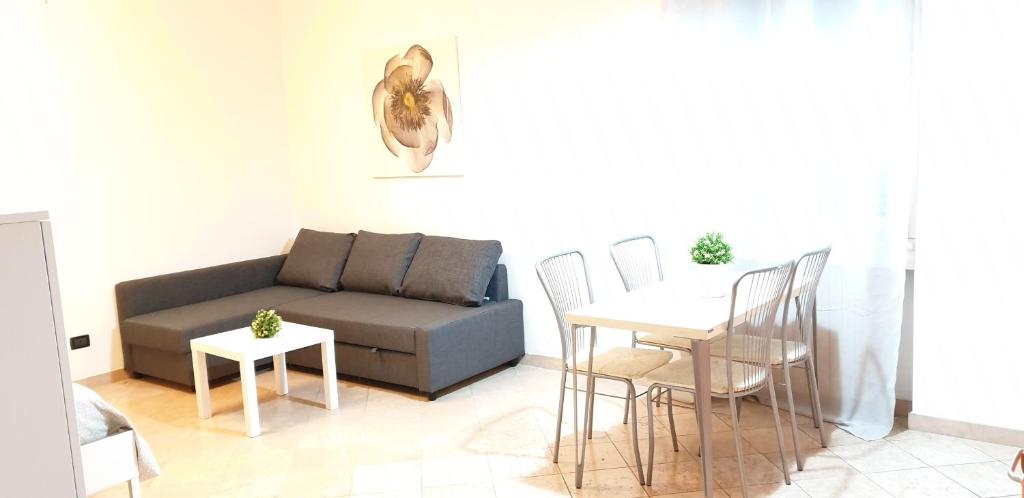 een woonkamer met een bank en een tafel en stoelen bij Philips apartment in Milaan
