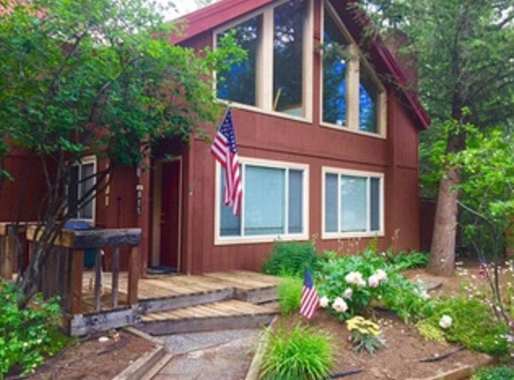 una casa con dos banderas americanas delante de ella en Longhorn Hideaway by Casago McCall - Donerightmanagement, en McCall