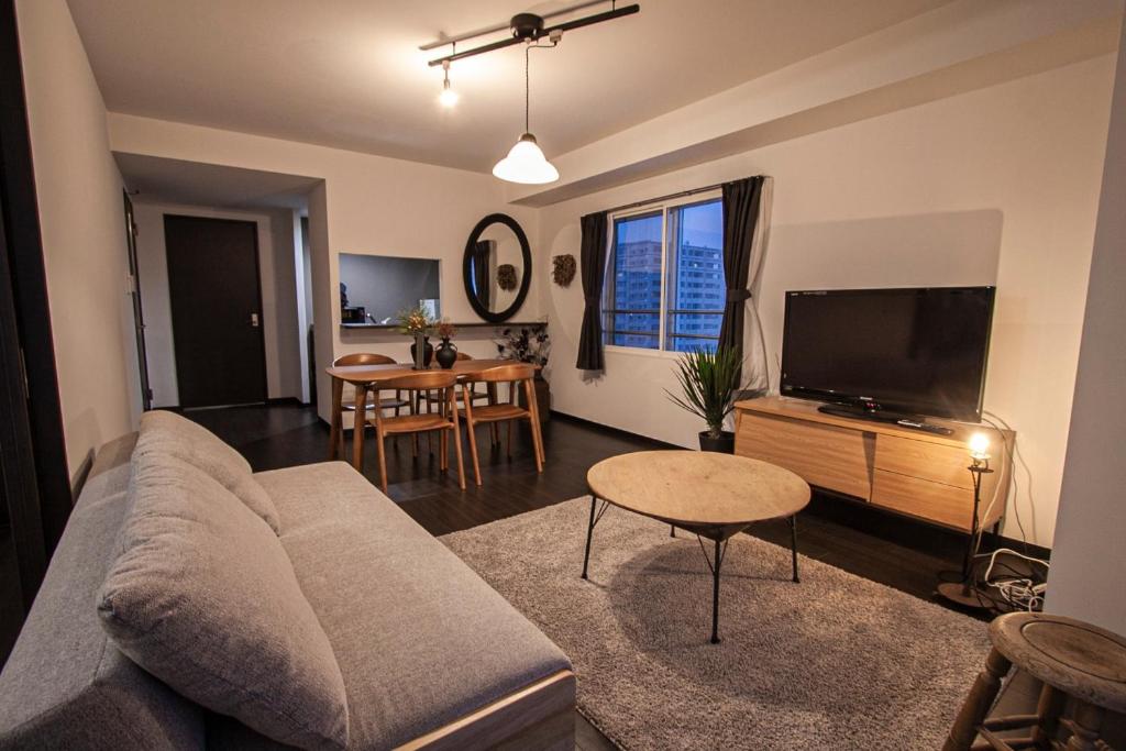 ein Wohnzimmer mit einem Sofa und einem Flachbild-TV in der Unterkunft Sun Court North 7 Ichibankan / Vacation STAY 7374 in Sapporo
