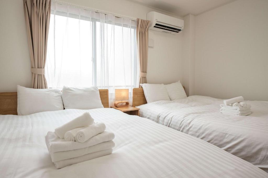2 Betten in einem Zimmer mit weißen Handtüchern darauf in der Unterkunft Noah Ikebukuro / Vacation STAY 7325 in Tokio