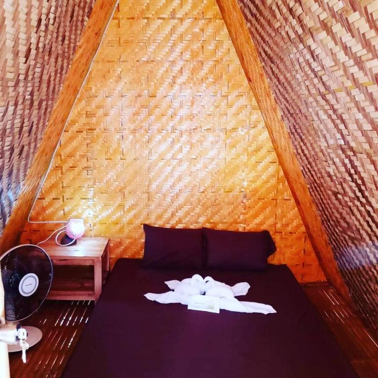 um quarto com uma cama e uma parede de madeira em SHUKRAN Apartelle em Siquijor