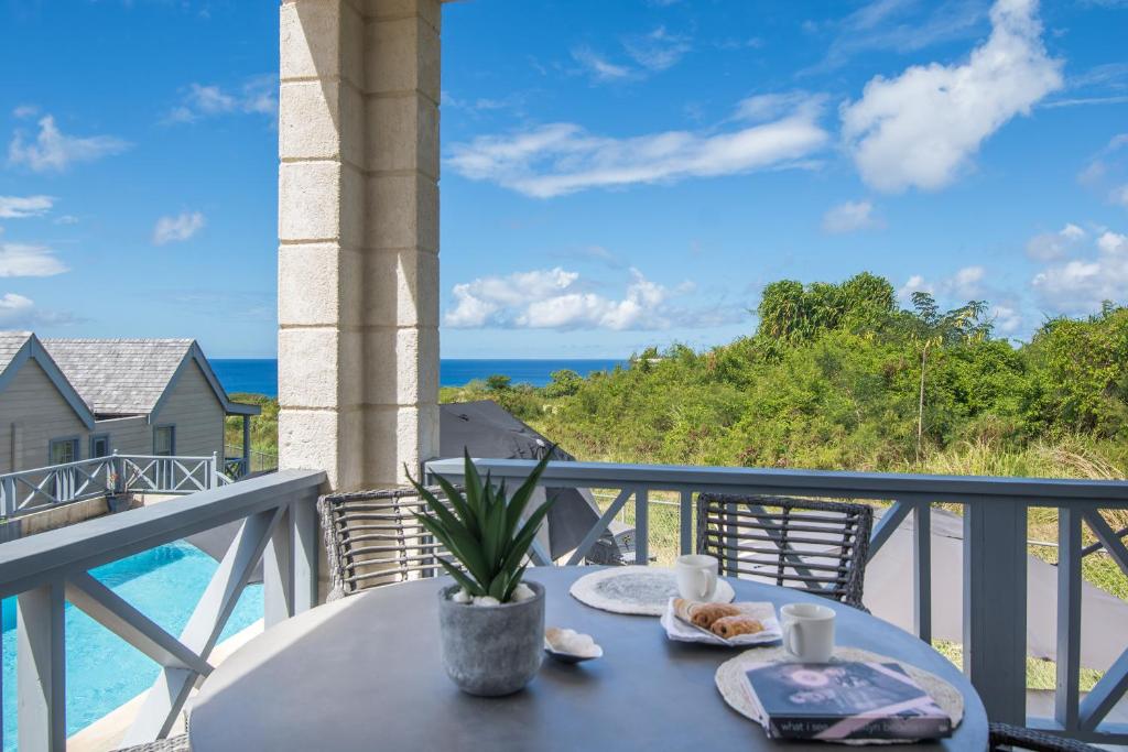 a table on a balcony with a view of the ocean at West Rock Villas in Saint James