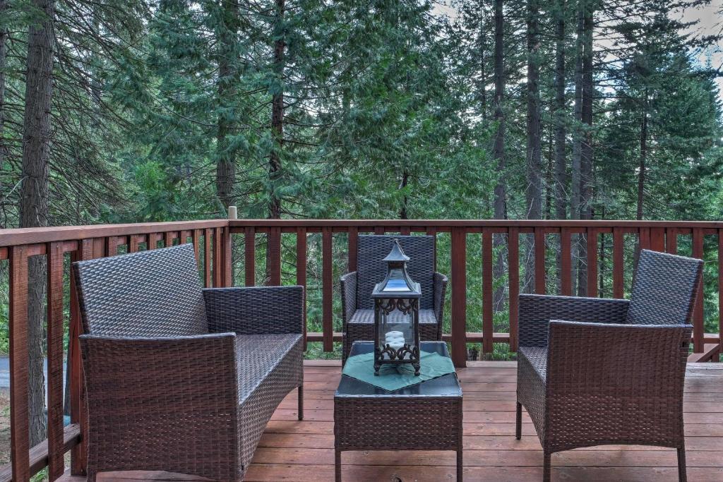 a patio with chairs and a table with a lantern at 4 Mi to Big Tree State Park Serene Cabin with Deck in Arnold