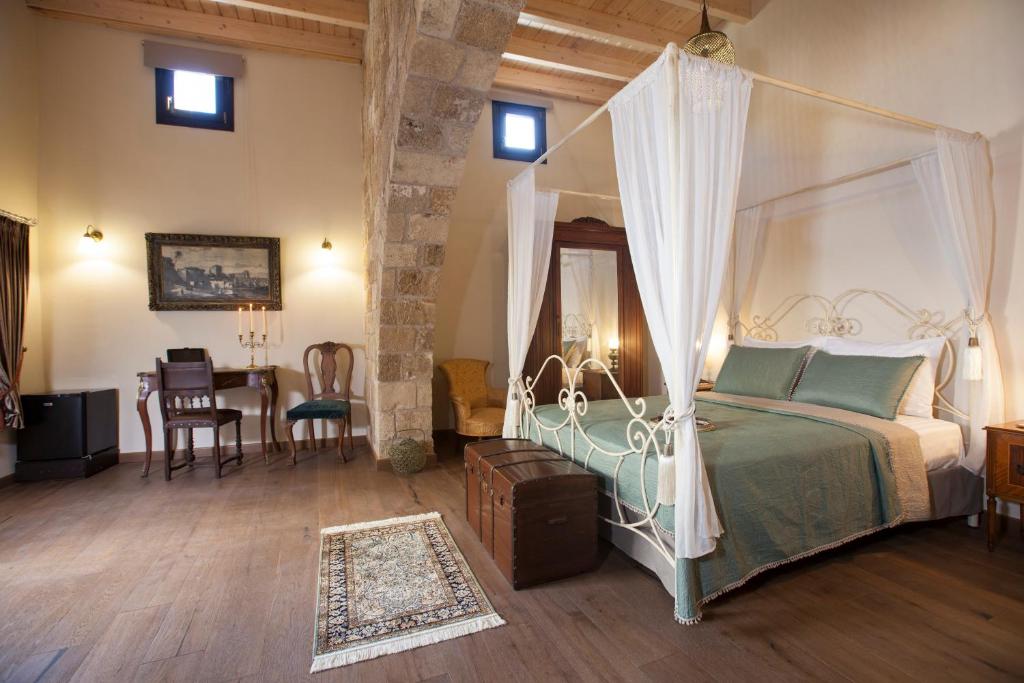 een slaapkamer met een hemelbed en een eetkamer bij Porolithos Boutique Hotel in Rhodos-stad