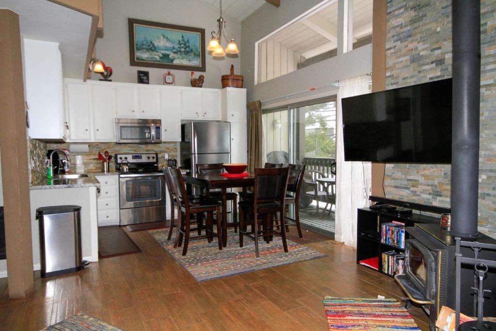 cocina con mesa y sillas y TV en Sierra Park Villas #03, en Mammoth Lakes
