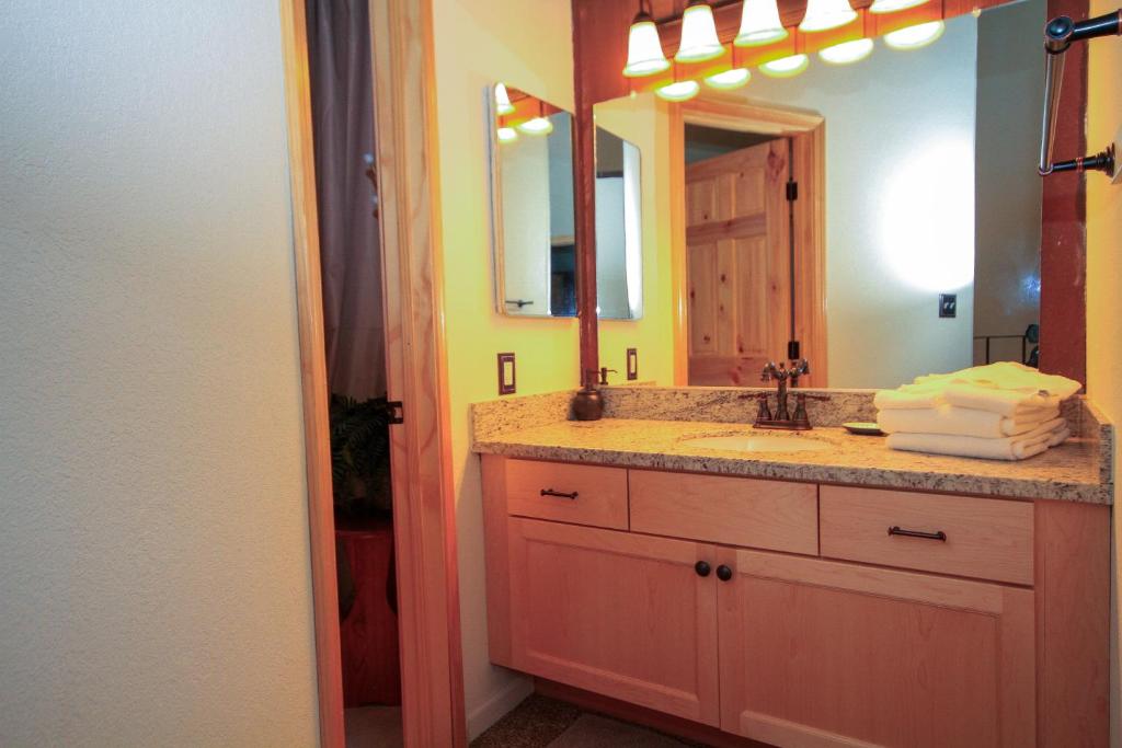 Un baño con lavabo y un espejo grande. en Sierra Park Villas #82, en Mammoth Lakes