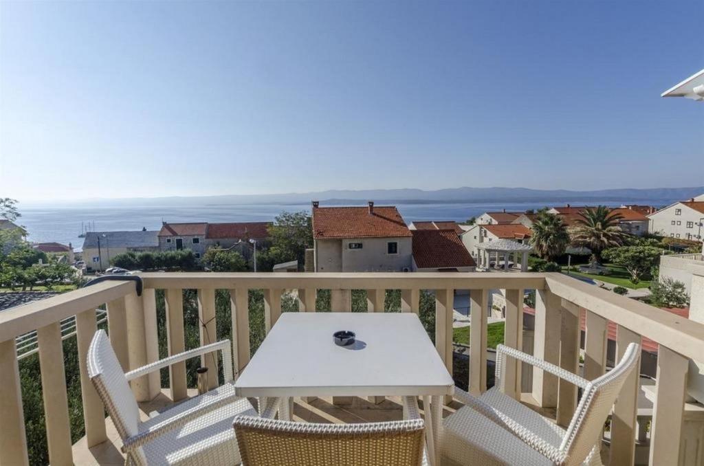 una mesa blanca y sillas en un balcón con vistas al océano en Apartments Lemar - with parking, en Bol